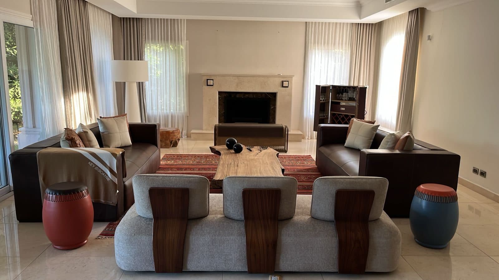 Living con chimenea, sofás de cuero y mesa de madera