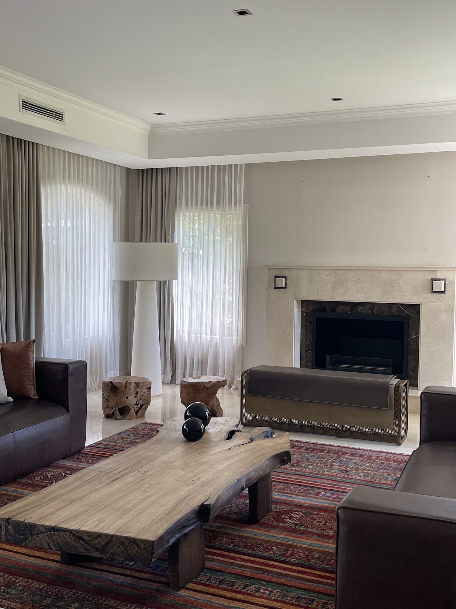 Chimenea de mármol y banco de cuero en un living