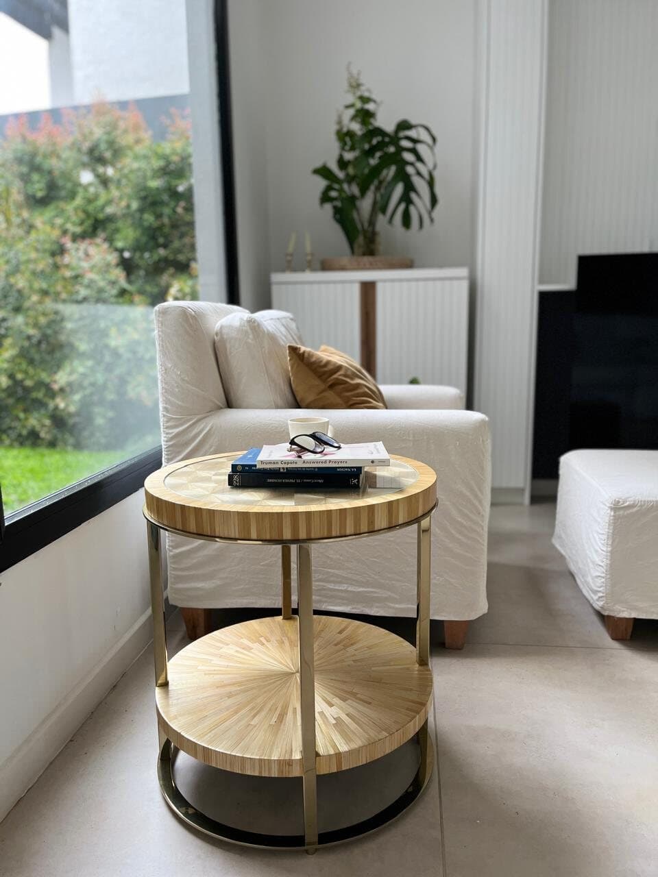 Estar con mesa auxiliar radial y sillón blanco